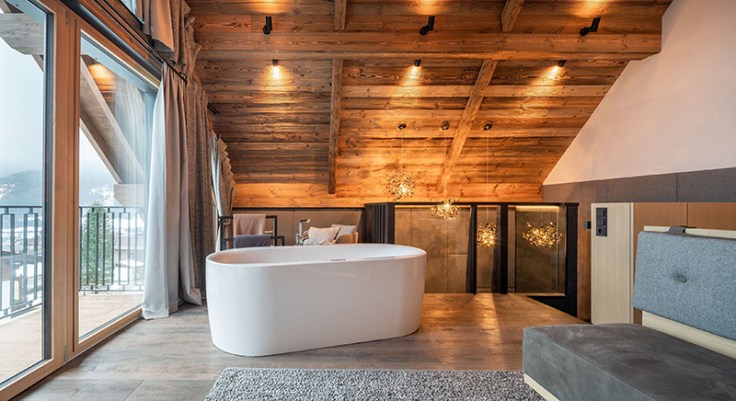 freistehende_whirlwanne_mit_blick_auf_die_berge_im_baumhaus_schlafzimmer_wanderhotel_gassner